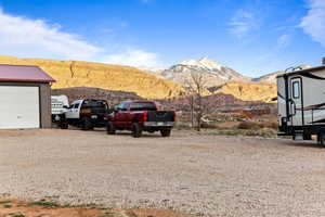 View of parking with a mountain view and gravel driveway