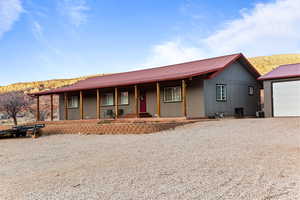 View of front of house featuring a porch, a metal roof, and a mountain view