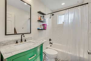 Full bathroom with vanity, shower / bathtub combination with curtain, and recessed lighting