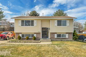Bi-level home featuring brick siding and entry steps