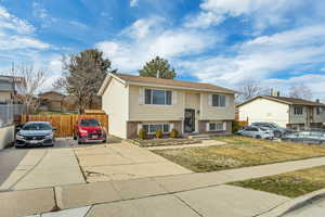 Bi-level home featuring brick siding, concrete driveway, and a residential view