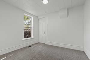 Carpeted empty room with baseboards
