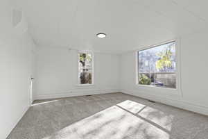 Spare room featuring carpet floors and baseboards