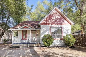 View of front facade featuring covered porch and a shingled roof