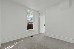 Carpeted empty room with baseboards