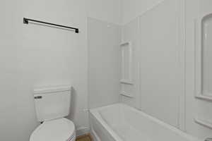 Full bathroom featuring shower / tub combination and a textured wall