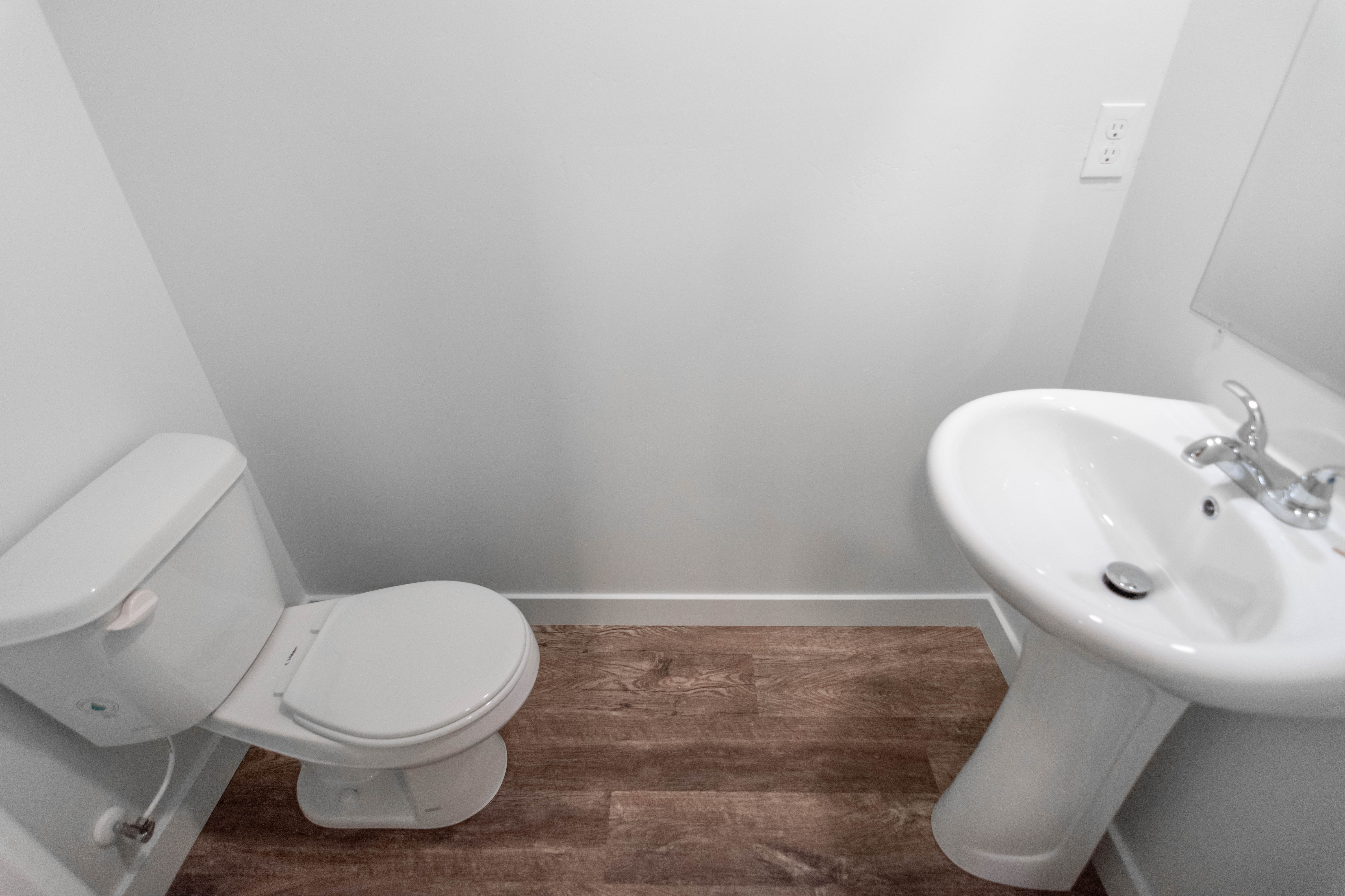 Bathroom with dark wood-style floors and baseboards