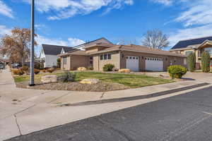 View of front of property with a garage, driveway, stucco siding, a tile roof, and a front yard