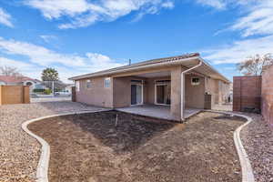 Rear view of property featuring a gate, a fenced backyard, stucco siding, a patio area, and a tiled roof