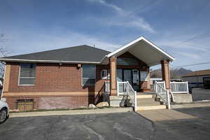 View of front of property with brick siding and a shingled roof