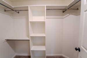 Walk in closet with dark carpet