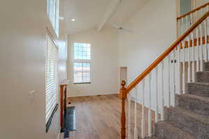 Staircase with a ceiling fan, wood finished floors, and recessed lighting