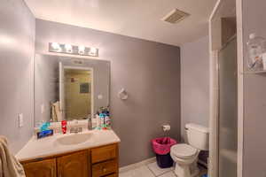 Full bathroom with vanity, a shower stall, and light tile patterned floors