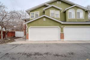 Traditional-style home with stucco siding, driveway, and a garage