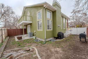 Back of house with a patio area, a fenced backyard, stucco siding, a chimney, and an outdoor fire pit