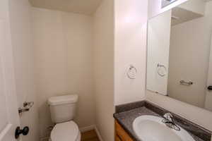 Half bathroom featuring vanity and toilet