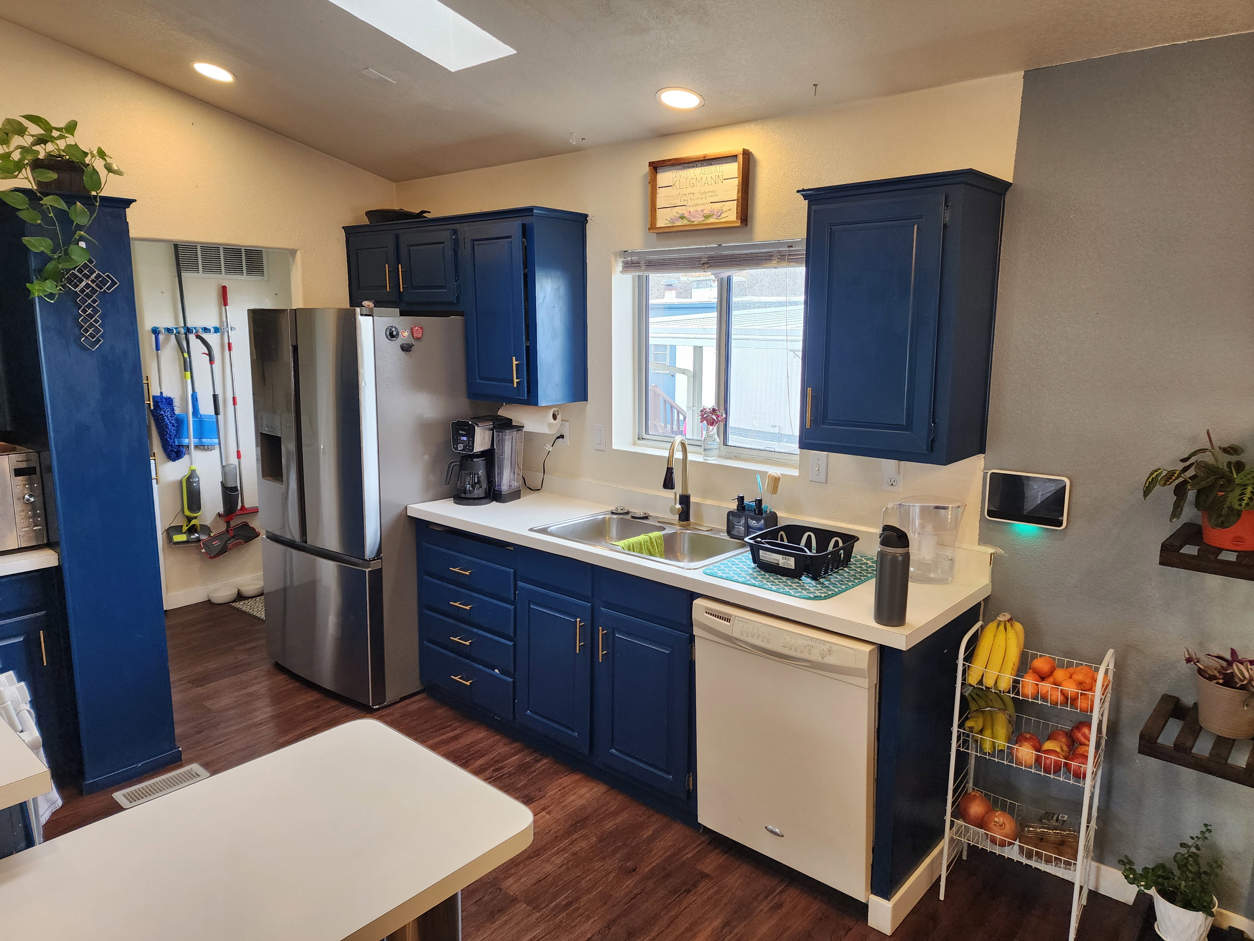Kitchen with light countertops, blue cabinets, a skylight, recessed lighting, and lofted ceiling