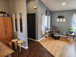 Living area with light wood-type flooring, lofted ceiling, and recessed lighting