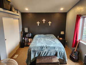 Bedroom featuring carpet flooring, an accent wall, and recessed lighting