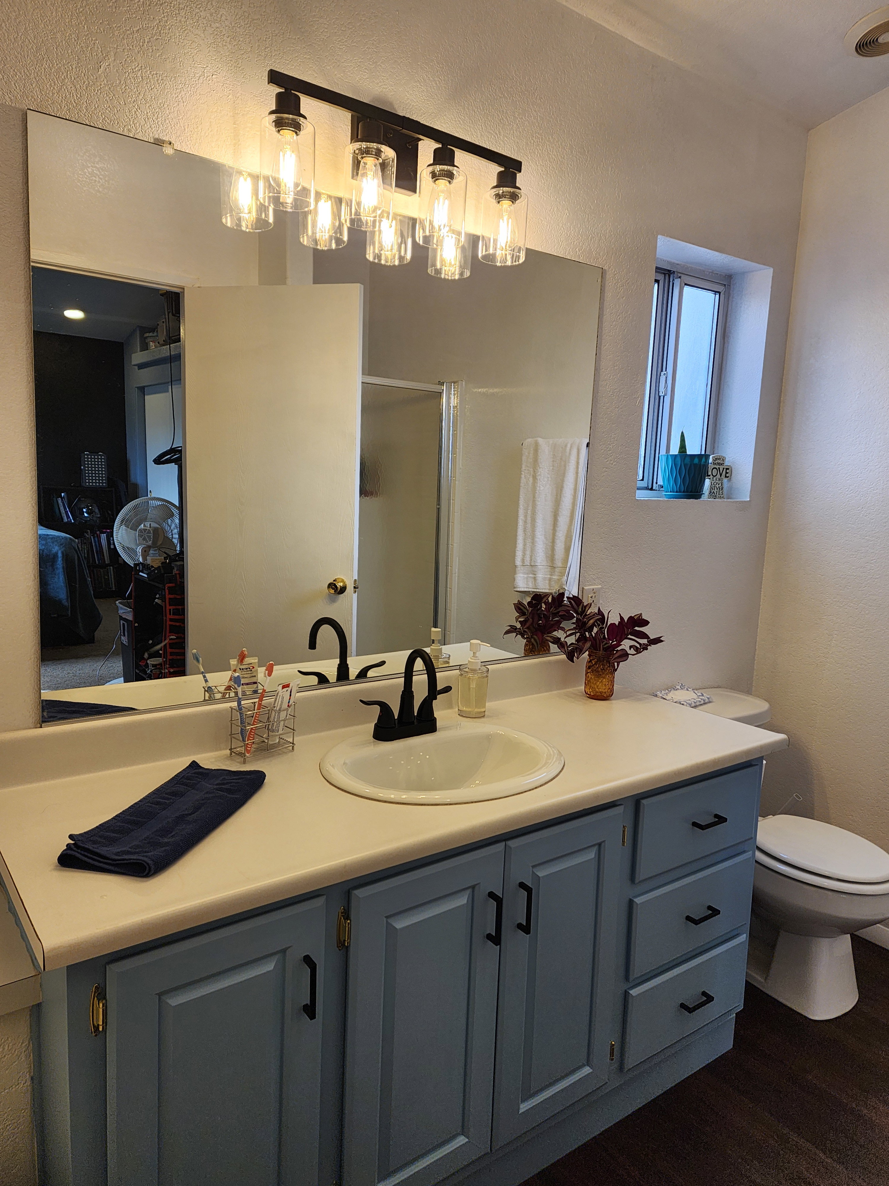 Full bathroom with a textured wall, vanity, dark wood-style flooring, and a stall shower