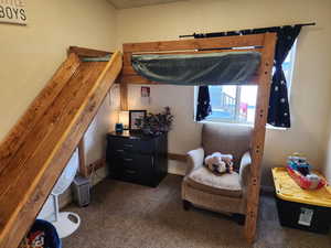 Bedroom with dark carpet and baseboards