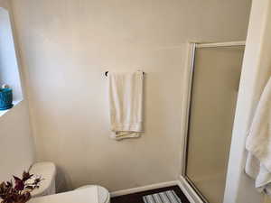 Full bath with a stall shower and baseboards