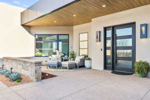 View of exterior entry featuring stucco siding and a patio area