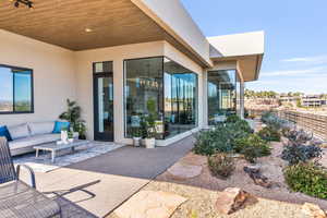 Doorway to property featuring a patio, outdoor furniture, and stucco siding