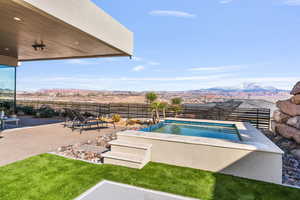 View of pool featuring a fenced backyard, a mountain view, and patio surround