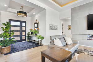 Entryway featuring a tray ceiling, hardwood / wood-style floors, and suspended lighting