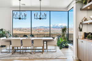 Dining room featuring a mountain view, a chandelier, and light wood-style flooring