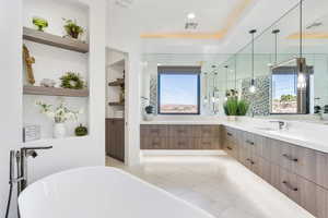 Bathroom with light tile patterned floors, a freestanding bath, vanity, built in features, and a closet