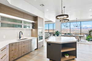Dual tone kitchen featuring a center island, two tone cabinetry, open shelves, modern cabinets, and light stone counters