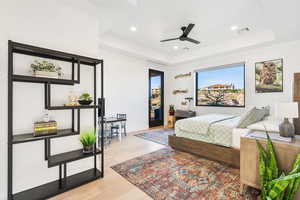 Bedroom with light wood-type flooring, access to outside, a raised ceiling, ceiling fan, and recessed lighting