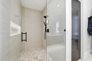 Oversized Shower with Pebble Flooring and backlit Shampoo Shelf