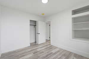 Unfurnished bedroom featuring light wood-type flooring and a closet