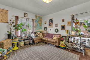 Living room featuring a textured ceiling and wood finished floors