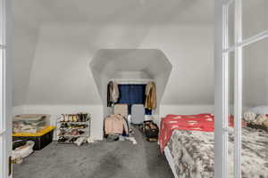 Carpeted bedroom featuring lofted ceiling