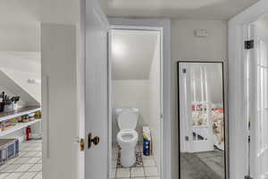 Bathroom with toilet and light tile patterned floors