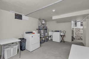 Finished below grade area featuring water heater and washing machine and clothes dryer