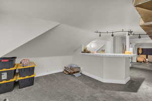 Bonus room with carpet flooring and vaulted ceiling