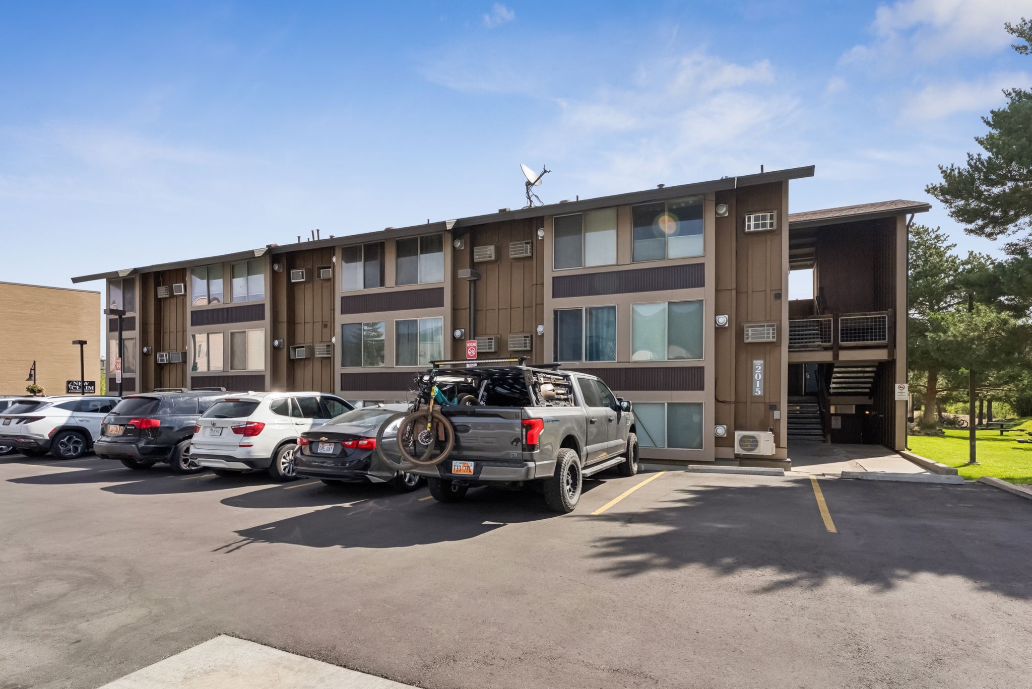 View of building exterior featuring uncovered parking