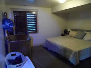 Bedroom featuring dark carpet and baseboards