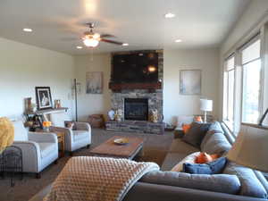 Carpeted living area with a fireplace and a ceiling fan
