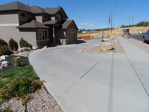 View of front of property with stucco siding, an attached garage, and concrete driveway