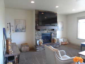 Carpeted living room featuring a fireplace and recessed lighting