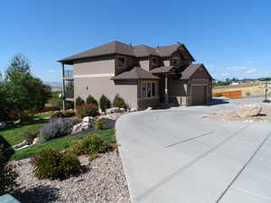 View of front of house with stucco siding, driveway, and an attached garage