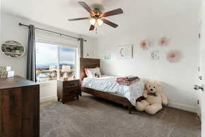 Bedroom with dark carpet and a ceiling fan