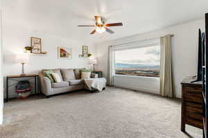 Living room featuring ceiling fan and light carpet