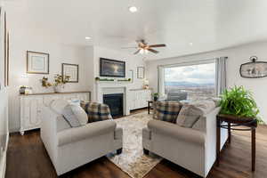 Living room with dark wood-style floors, a ceiling fan, recessed lighting, and a fireplace with flush hearth